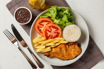 Executive dish with breaded fillet, rice, beans and salad.