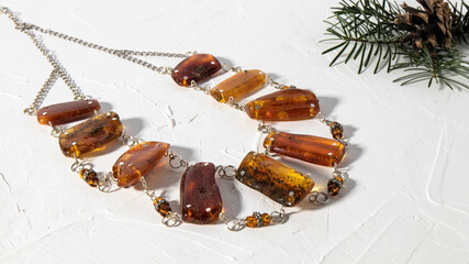 Beautiful transparent orange amber necklace on a white plastered background. Isolated amber jewelry...