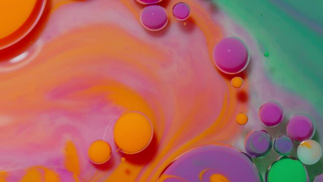 Bright neon colorful bubbles oil and ink, beautiful fluorescent paint. Sparkling color multicolor moving close-up. Acrylic painting. Themes or wallpaper background. Abstract transformation gravitation