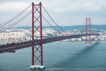 Modern bridge On April 25 in Lisbon, the capital of Portugal, in cloudy cloudy weather, cars drive on the gigantic bridge across the strait.