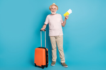 Full body photo of aged man happy positive smile hold tickets passport baggage trip isolated over blue color background