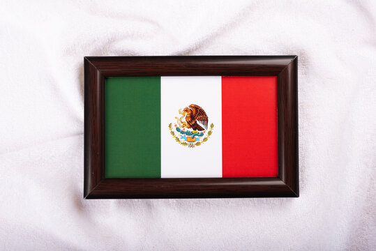 Mexico flag in a realistic frame on white cloth background flat lay photo