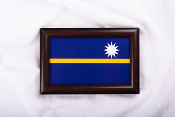 Nauru flag in a realistic frame on white cloth background flat lay photo