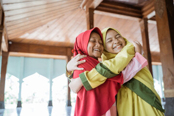Fototapeta na wymiar portrait asian kids girl Muslim laugh happiness and hug each other in mosque