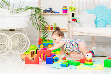 the baby is playing at home in the nursery. Toys for small children. A child with educational toys. Early development