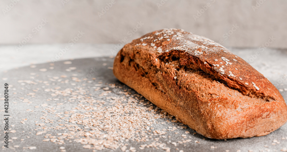 Wall mural Healthy speal bread with sown flakes on a new table and a bright background. Copy space for text.