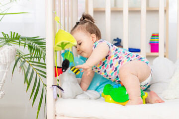 baby plays mobile in crib at home, early development