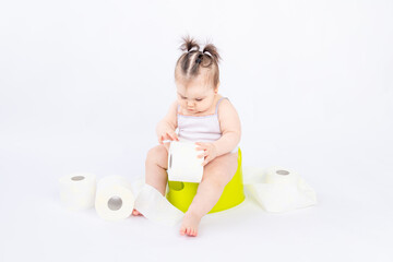 baby on a green potty with toilet paper on a white insulated background, space for text