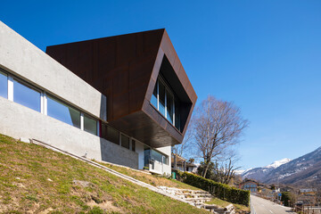 Exterior modern isolated villa, surrounded by nature. Iron and concrete cladding