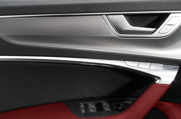 Obraz na płótnie Canvas Car door handle inside the luxury modern car with red leather texture with stitching. Switch button control. Modern car interior details. Red perforated leather