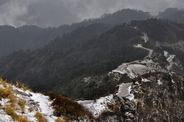Ariel view of mountain slope with cloudy sky.