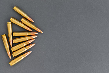 Group of bullets on gray paper background. Cartridges 7.62 caliber for Kalashnikov assault rifle,...
