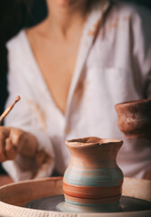 Fototapeta na wymiar hands of a potter, creating an earthen jar on the circle. Potter's wheel. Horizontal