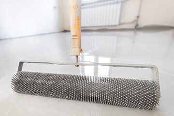 Close-up leveling tool for self-leveling floor. Leveling with a mixture of cement floors with a...