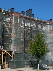 Scaffolding around the building, workers restoring the facade of the old building.