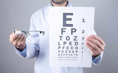 Caucasian doctor showing eyeglasses and eye examination test.