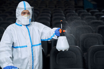 Man making disinfection in cinema.