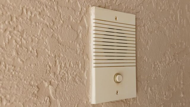 Ringing doorbell with thumb. Closeup of male hand pushing home intercom door bell button.