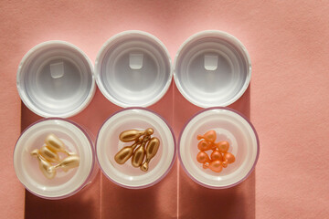 Serums and ampoules for facial skin care at home. Pastel pink background. Retinol, vitamins, collagens and acids. Top view with copy space.
