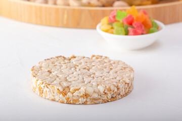 Puffed exploded wheat grains on candied fruit background on white wooden table