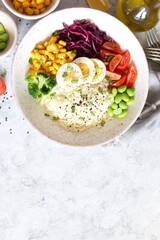 Rice salad with vegetables and sesame on light background. Top view with copy space. Healthy eating.