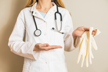 Image of female doctor showing protective gloves.	