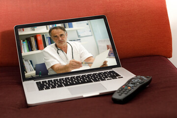 Dottore fornisce una consulenza medica a distanza con una video call vista da un computer portatile...