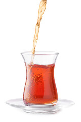 Pouring of hot Turkish tea into glass on white background