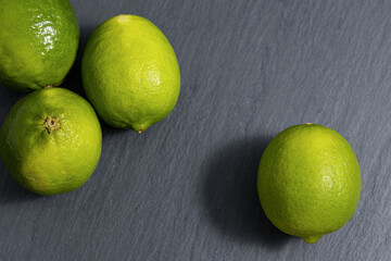 Fresh lime fruits on dark slate background