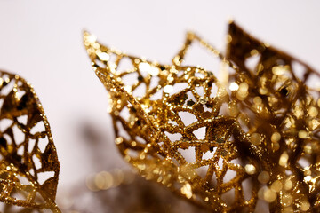 Beautiful background of shiny golden artificial leaves with glitter. Golden artificial leaves with...