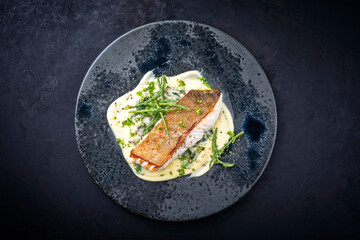 Modern style traditional fried skrei cod fish filet with mashed potatoes and glasswort served as top view on ceramic design plate with copy space - obrazy, fototapety, plakaty