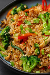 Asian rice with vegetables: zucchini, broccoli, red bel pepper, mushrooms, carrot, spring onion and...
