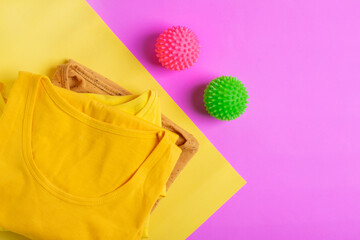 Laundry balls for washing machine and yellow folded shirts on the geometric background. Taking care of clothes