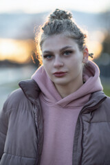 Portrait of a young beautiful blonde girl in the evening on a city street.