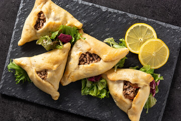 Traditional middle eastern fatayer on black stone. Top view