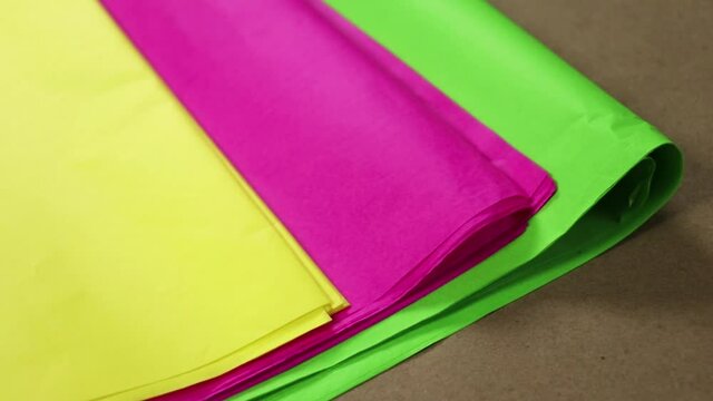 Tissue paper in bright colors: yellow, pink and green. Paper for crafts, pi&ntilde;atas and decorations. Close up.