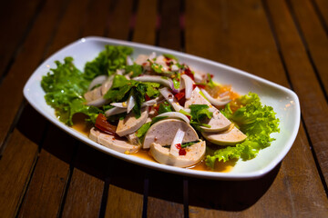 Thai food, Yum Moo Yor on the table at the restaurant at night