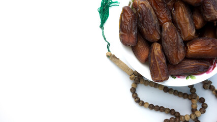 Top view photo of dates and tasbih or rosary beads in white background. Ramadan conceptual photo. Fasting conceptual photo. Copy space.