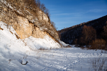 mountainous terrain sun cliffs. earlier morning frost snow. cold season. Spring light is warm. The silence of nature