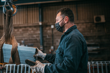 adult man in uniform works in an industry with machinery