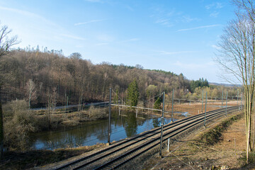 View on train tracks a lake and a road during a sunny day