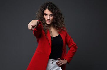 Portrait of a beautiful girl in a red jacket on a gray background