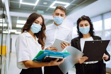 Business colleagues in protective face mask  discussing together work issues. Teamwork of Business people during pandemic of coronavirus. Covid-19.