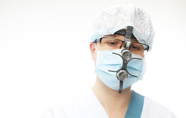 A doctor wearing a medical mask and wearing a device on his head