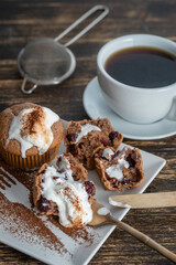 Sweet cherry muffin with ice cream and white cup with tea on a wooden background