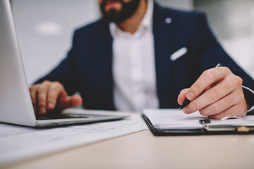 Crop businessman browsing netbook in office