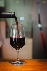 serving a glass of wine and bottle