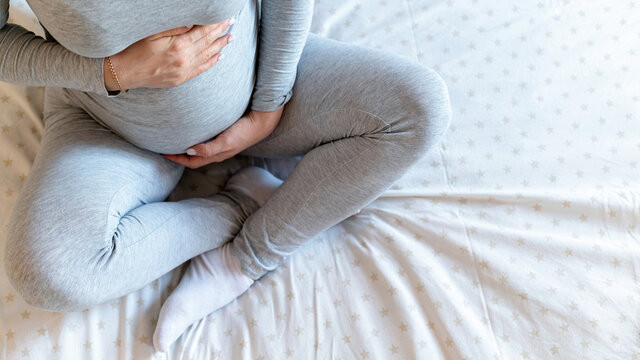 Pregnant woman sitting on the bed