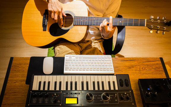man playing acoustic guitar while learning music lesson from internet. e-learning concept
