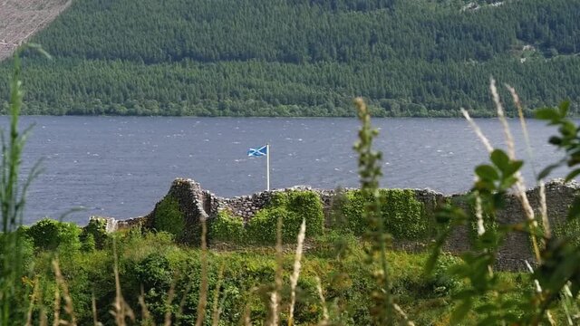Still Slow motion shot of Urquhart Castle ruins in Scottish Highlands with Flag Loch Ness Drumnadrochit Scotland UK 1920x1080 HD